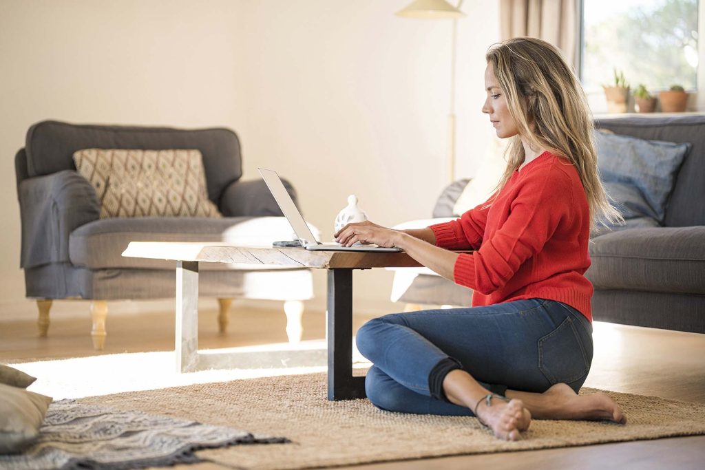 woman-using-laptop-on-coffee-table-at-home-6QGZXN5.jpg